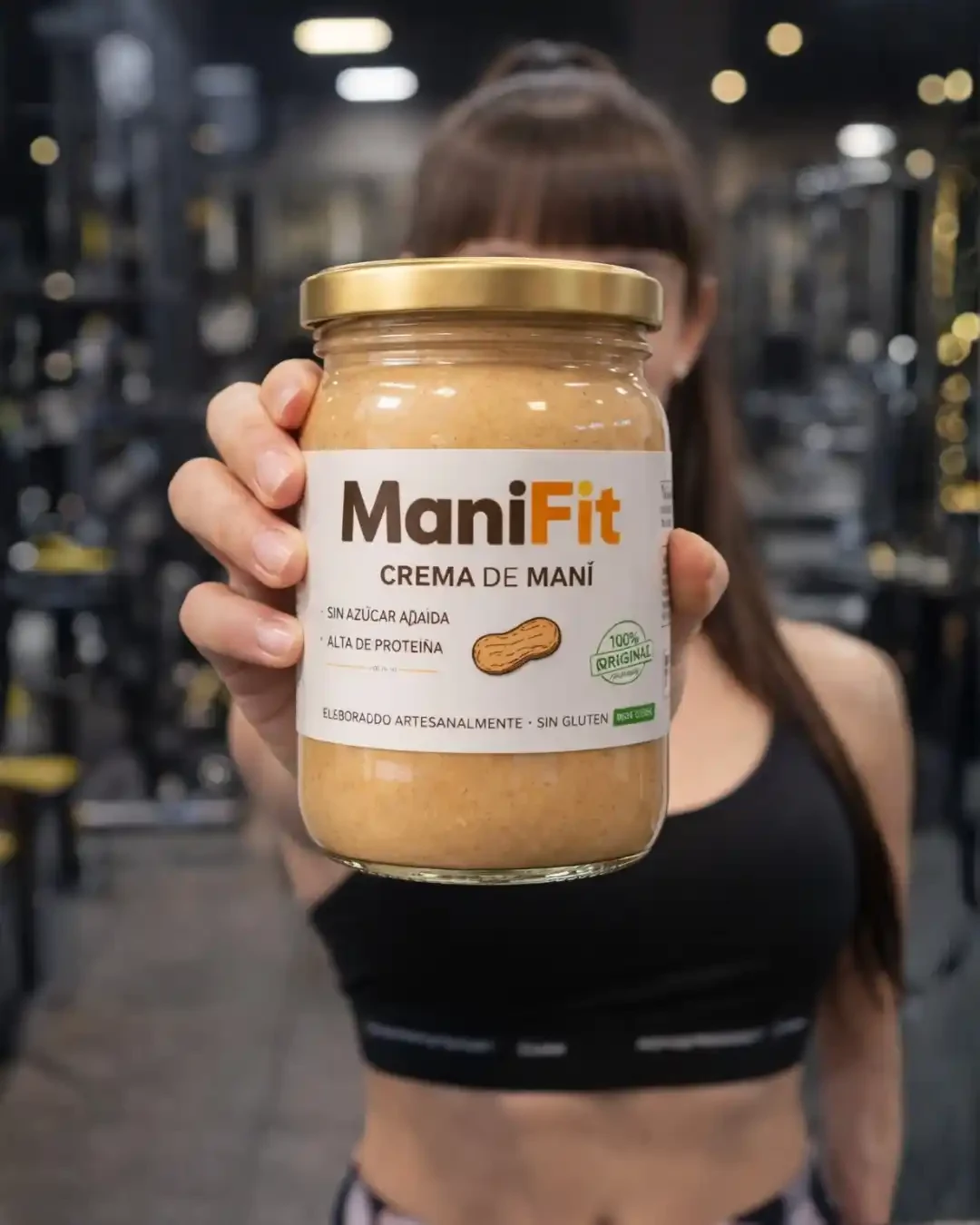 Mujer sosteniendo un frasco ManiFit en el gimnasio